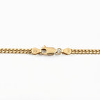 Close-up of a gold chain bracelet showing a lobster clasp with '14K' hallmarks on a plain white background.