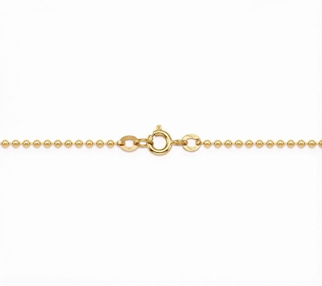 A close-up of a gold ball chain necklace showing the lobster clasp and a small circular brand engraving on a plain white background.